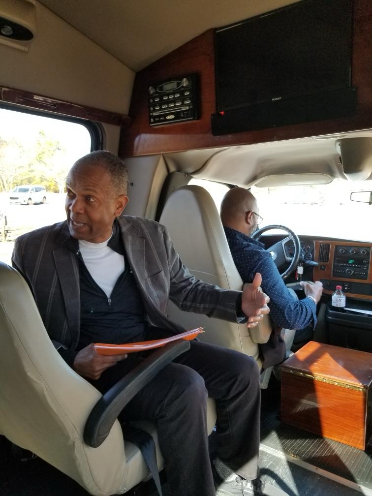 inside of bus with man in front row speaking